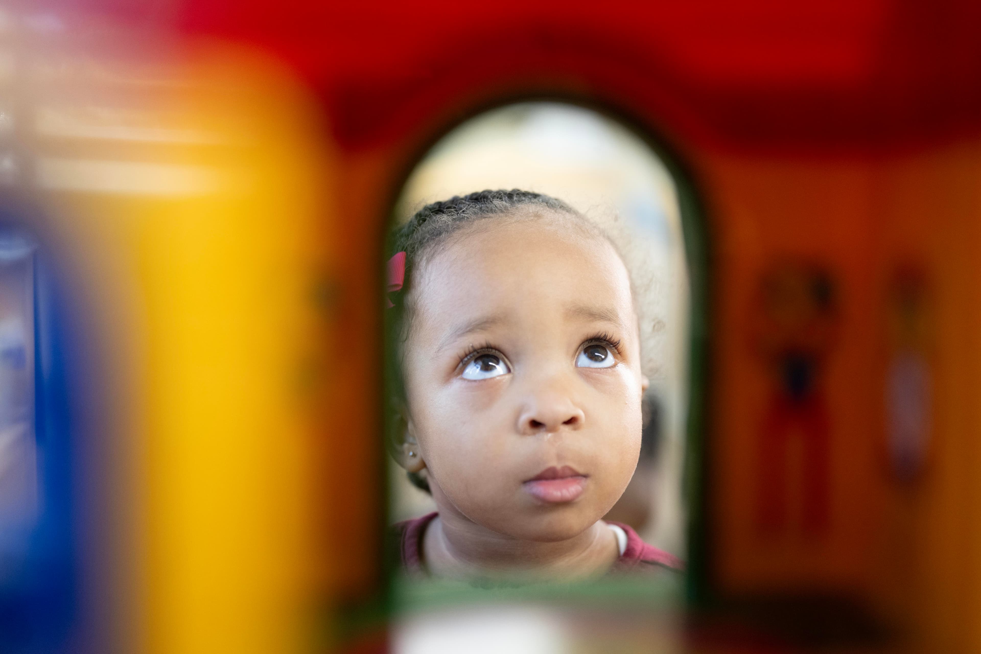 toddler child looking through toys blocks